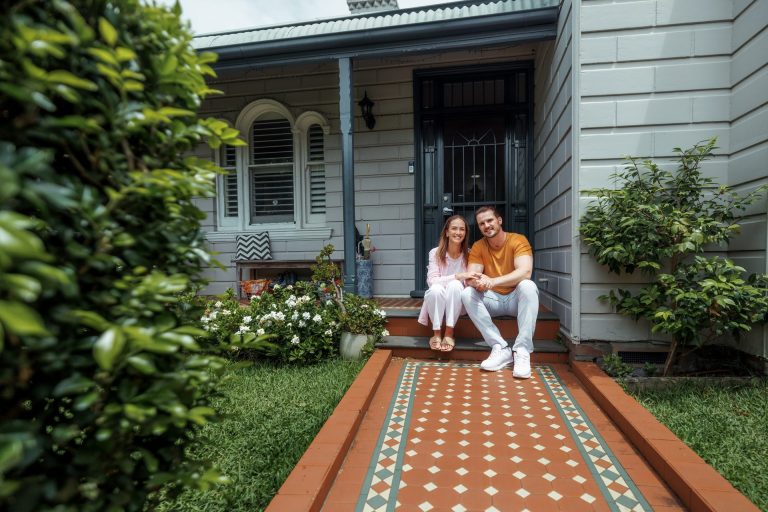 Couple sitting on front steps of suburban home