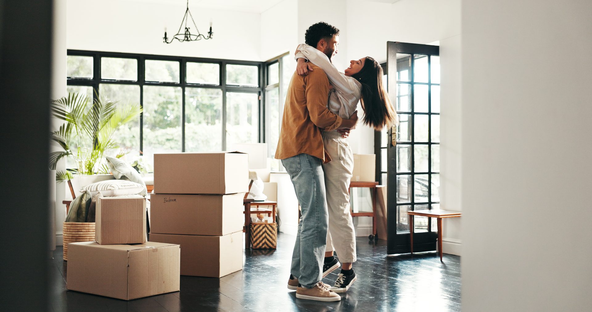 Couple hugging in new home with boxes