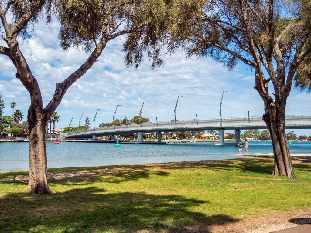 Pedestrian bridge over river framed by trees
