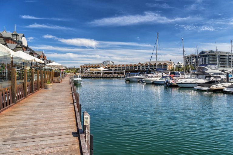 Marina with boats and waterfront boardwalk cafes