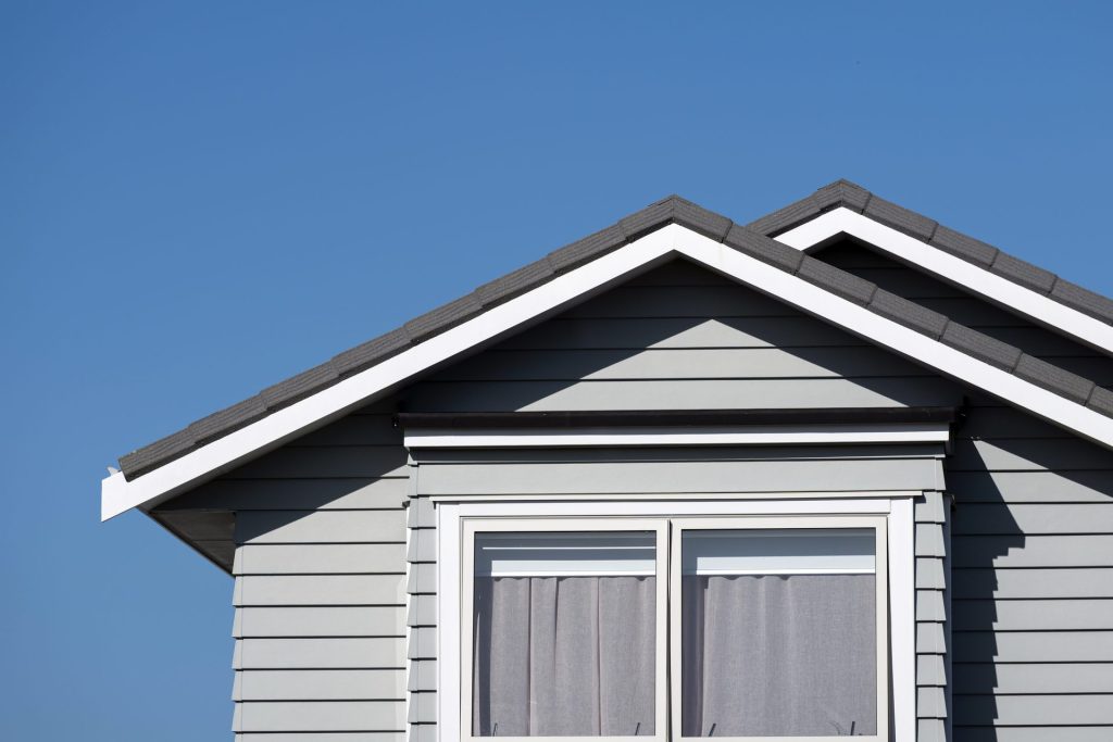 Modern house gable with window under blue sky