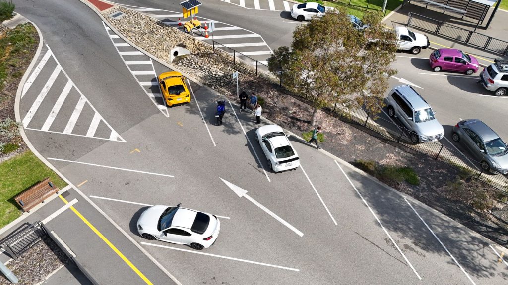 Aerial view capturing traffic at a busy intersection in Burswood, Perth, Australia. Cars and pedestrians in the scene.