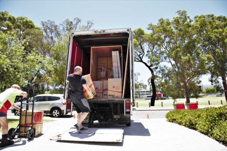 Removalists unloading boxes from moving truck