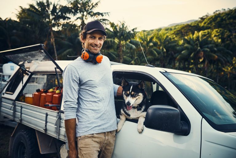 Man and husky beside white ute